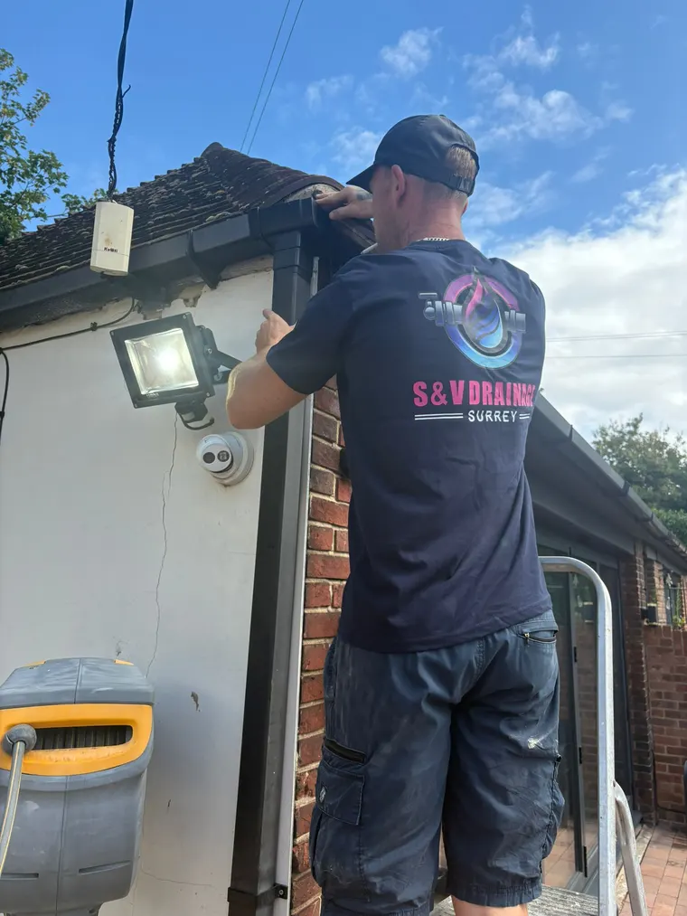 S&V Drainage engineer clearing a blocked downpipe and gutter